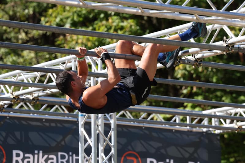 Athlet hangelt kopfüber am Rig