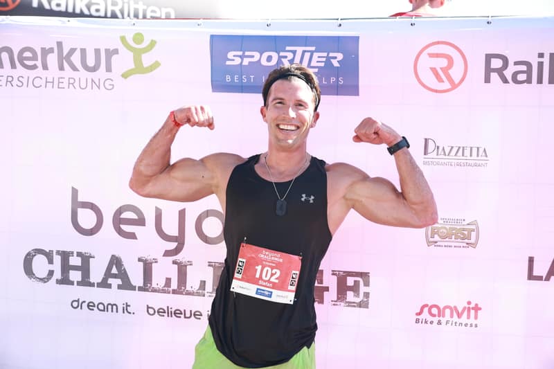 Finisher zeigt seine Muskeln an der Sponsorenwand